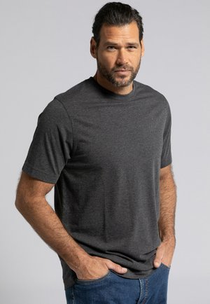 T-shirt gris à manches courtes en coton doux, avec un col rond et un logo discret sur la poitrine. Associé à un jeans en denim bleu.