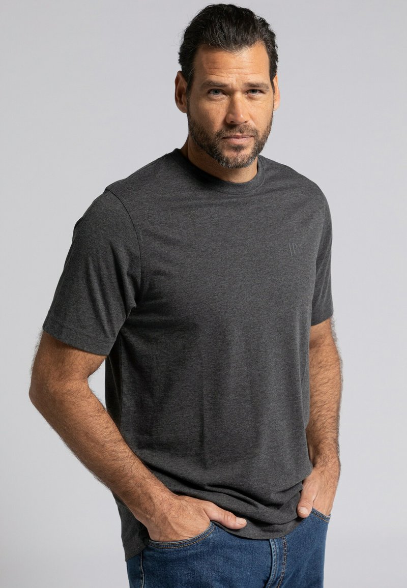 T-shirt grigio a maniche corte realizzato in morbido cotone, con colletto a girocollo e un logo discreto sul petto. Abbinato a jeans in denim blu.