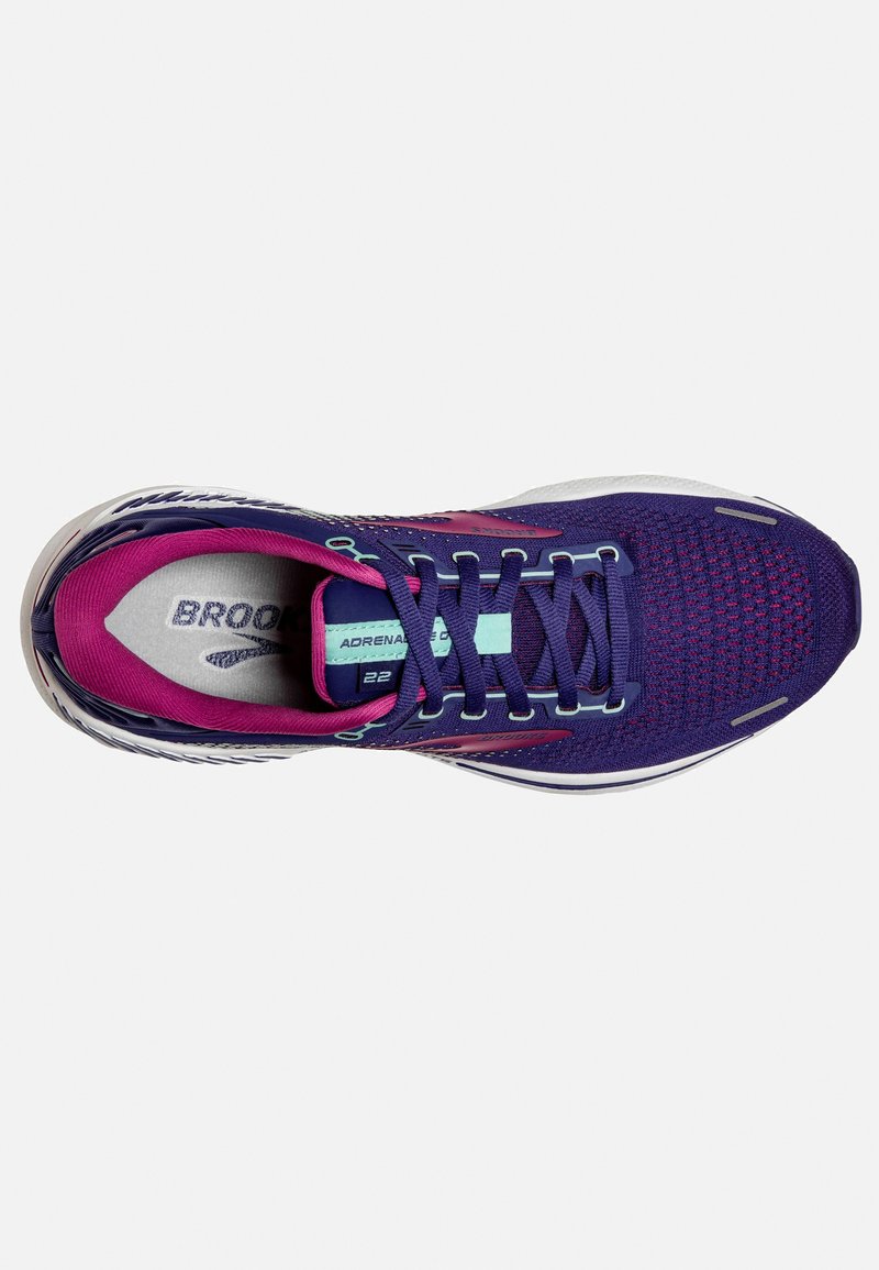 Zapatilla de running morada con parte superior de malla transpirable, forro interior rosa en contraste, cordones planos y suela de goma blanca con detalles texturizados.