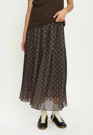Brown polka dot maxi skirt made of lightweight fabric, featuring a pleated design, flowing texture, and an elastic waistband.