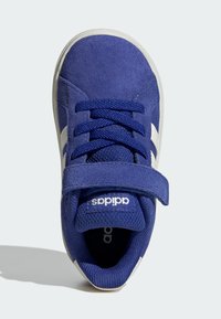 Modré tenisky Adidas s bílými pruhy, tkaničkami a suchým zipem, zobrazené z vrchu na světlém pozadí.