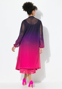 Genomskinlig klänning med en ombre-design som övergår från mörk lila till ljus rosa, med långa ärmar och en flödig silhuett. Rosa klackar fulländar outfiten.