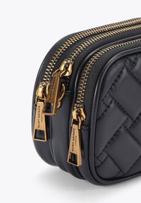 Czarna pikowana skórzana torba z podwójnymi złotymi suwakami i uchwytami, o kompaktowym prostokątnym kształcie i gładkiej fakturze.