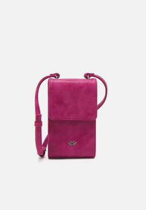 Pequeño bolso bandolera de ante rosa brillante con cierre de solapa y correa ajustable, con un pequeño logo plateado de corazón y alas en la parte delantera.
