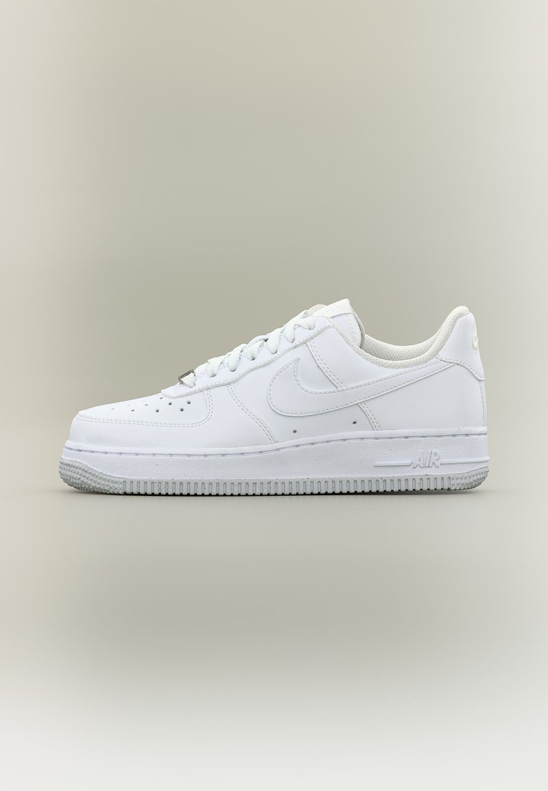 Biały, niskoprofilowy sneaker Nike Air Force 1 z sznurowadłami, perforowanym noskiem i teksturowaną gumową podeszwą na neutralnym tle.