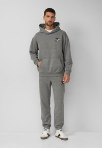 Grijze katoenen hoodie en sweatpants set met een frontzak, ribgebreide manchetten en een Snoopy borduursel op de borst en het been.