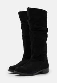 Bottes en velours noir jusqu'au genou avec un design froncé, semelle en caoutchouc plate et une forme légèrement effilée. Fini texturé et doux sur l'ensemble.