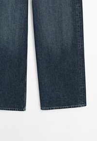 Mörkblå denimjeans med rak ben-design, med en ren fåll och subtil textur. Inga synliga detaljer eller dekorationer.