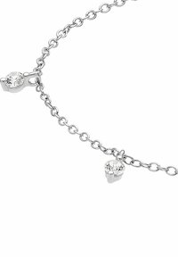 Pulsera de cadena de plata con dos pequeños charms redondos de piedra preciosa transparente unidos a los eslabones sobre un fondo blanco.