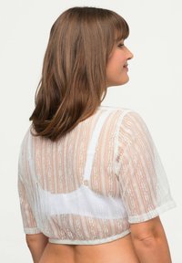 Weißes Spitzencrop-Top mit kurzen Ärmeln, das horizontale Streifen und florale Muster aufweist und eine weiche, halbtransparente Textur präsentiert.