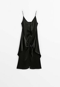 Combinaison noir en satin sans manches avec fines bretelles, col en V, fermeture éclair à l'avant et détail noué à la taille, présentée sur un fond blanc.