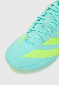 Aqua blue athletic shoe with neon green accents, textured upper, and flat laces. Features a prominent "ADIZERO" logo on the side.
