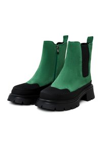 Groene suede enkellaarsjes met een stevige zwarte rubberen zool, een zijrits en een gestructureerde neus. Beschikt over elastische zijpanelen voor een goede pasvorm.