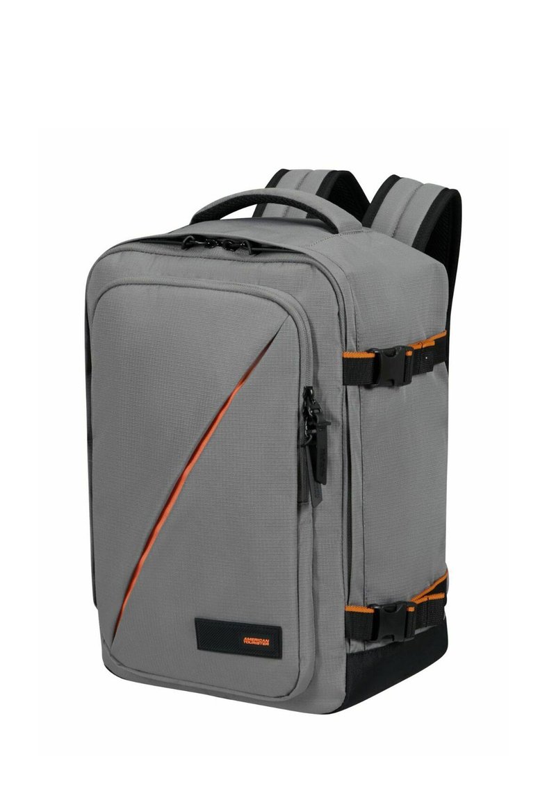 Grå tygryggsäck med en strukturerad design, orange detaljer, dubbla sidoklipp och ett handtag på toppen. Har en zippered framficka.