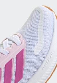 Zapatilla blanca con parte superior de malla, detalles en rosa y texturizados. Cuenta con cordones redondos, suela de goma y la marca "CLOUDfoam".