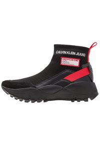 Černé vysoké ponožkové tenisky s robustní podešví, červené poutko, červené detaily na pásku a branding "Calvin Klein Jeans" na kotníku a nášivce.