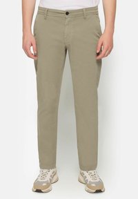 Light khaki pants with a straight leg design, five pocket styling, and a button closure. Worn with beige and gray textured sneakers.