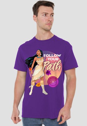 Man wearing purple t-shirt with illustration of a Native American woman, autumn leaves, compass, and text "Follow Your Path."