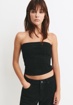 Top fără bretele din denim negru cu un design mulat, având puncte albe subtile, lungime scurtă și cusături structurate.