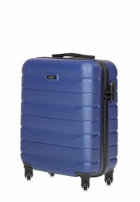 Niebieska twarda walizka z teksturowaną powierzchnią, pionowymi nacięciami, czarnym zamkiem błyskawicznym oraz 4 kółkami dla łatwości przemieszczania. Posiada uchwyt na górze.