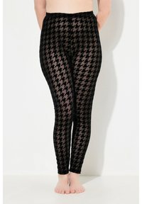 Leggings neri con motivo a pied de poule, realizzati in un materiale trasparente e strutturato con vita elastica.