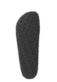 Suela de zapato de goma negra con un patrón ondulado, que presenta una superficie texturizada para mejorar el agarre. Forma ligeramente redondeada, con un borde suave.