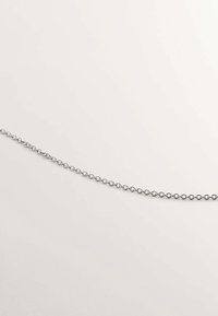 Cadena de metal plateado con eslabones redondos, que presenta un acabado suave y brillante. Los eslabones son uniformes en forma y tamaño, creando un patrón continuo.