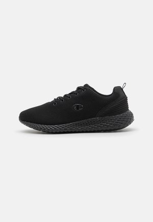 Scarpe sportive nere con tomaia in rete, punta arrotondata e suola testurizzata. Le caratteristiche includono lacci, logo e linguetta sul tallone per una facile calzata.