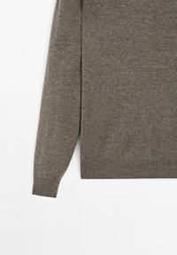 Jasnobrązowy, dziany sweter z długimi rękawami. Miękka tekstura, prążkowane mankiety i okrągły dekolt. Prosty, klasyczny fason bez ozdób.