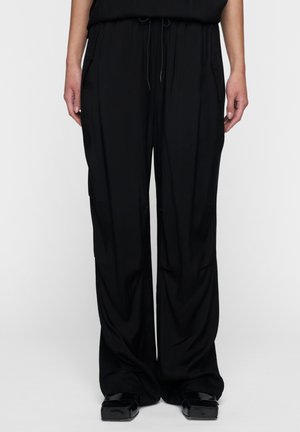 Pantaloni neri a gamba larga con vita regolabile, realizzati in tessuto morbido. Il design presenta tasche su entrambi i lati per maggiore comodità.