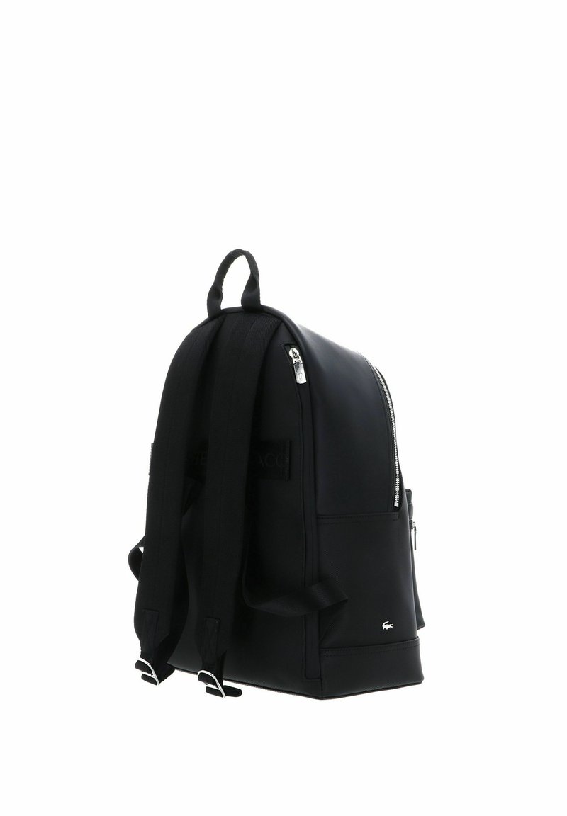 Black leather backpack with a smooth texture, rectangular shape, adjustable straps, and a top handle. Features a silver zipper and logo detail.