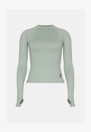 Vartaloa myötäilevä pitkähihainen vaaleanvihreä urheilupaita peukaloaukkoineen ja pienellä mustalla logolla alaoikealla.