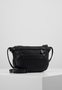 Borsa a tracolla in pelle nera con una texture granulosa, chiusura a zip, tasca frontale e tracolla regolabile. Dettagli metallici completano il design.