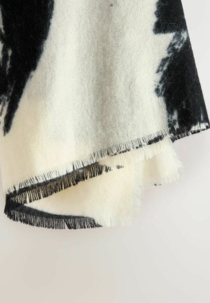 Mustavalkoinen kuvioitu huivi, jossa on hapsuhelpukset, valmistettu pehmeästä, tekstuuri-kankaasta ja esittelee tummien ja vaaleiden värien sekoitusta.