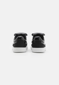 Sorte semsket og patenterte lær sneakers med hvit såle. Har en polstret krage og subtil merking på hælen.