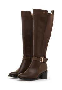 Botas marrones hasta la rodilla hechas de cuero suave, con cremallera lateral, tira de tobillo texturizada con detalle de hebilla y tacón grueso.