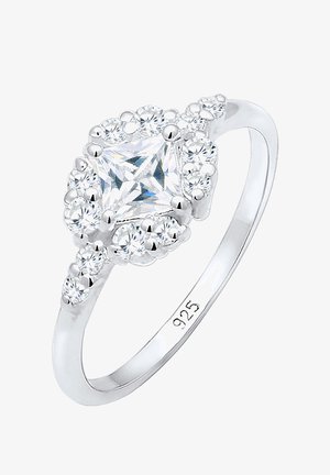 Zilveren ring met een centrale prinsessenslijpheldere steen omringd door kleinere ronde stenen, met een gepolijst bandje waarop "925" is gegraveerd.