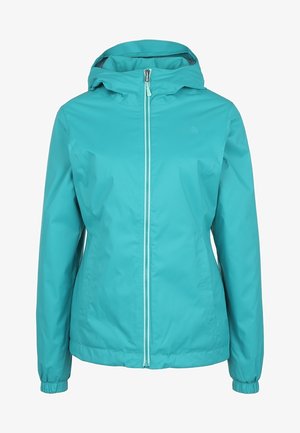 Personne portant une veste à capuche turquoise, un chemisier noir à manches longues, un pantalon de plein air noir avec une poche zippée et des chaussures de randonnée noires.