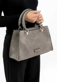 Borsa a mano grigia con finitura liscia, caratterizzata da dettagli laterali intrecciati, accessori in tonalità oro e doppi manici superiori. Design strutturato.