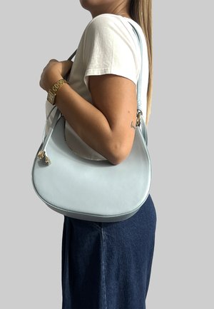 Borsa a mano in pelle blu chiaro con design curvo e tracolla laterale, dotata di hardware in tonalità argentata e una superficie liscia.