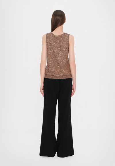 Top sans manches en bronze scintillant avec un ourlet côtelé, associé à un pantalon noir à jambes larges. Le tissu a une surface texturée et brillante.