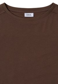 Bruine katoenen t-shirt met een ronde halslijn, voorzien van een label met de tekst "CECIL." De stof ziet er zacht en glad uit met een effen textuur.