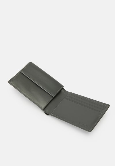 Folded wallet in dark green leather, featuring a smooth texture, a flap closure, and multiple card slots on one side.