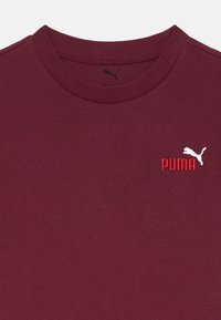 Bordeaux katoenen t-shirt met een ronde hals en korte mouwen. Bevat een witte geborduurde Puma-logo met rode accenttekst.