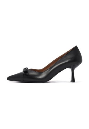 Scarpa nera in pelle con tacco alto e punta affilata, caratterizzata da un piccolo fiocco decorativo sulla parte superiore e da un design unico e snodato del tacco.