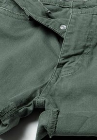 Shorts en coton vert olive avec fermeture à bouton sur le devant, ourlet roulé et détails cousus sur les poches et la ceinture.