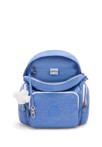 Modrý látkový batoh s kulatým tvarem, dvěma zipovými přihrádkami, přední kapsou a připojeným bílým pom-pom přívěskem.