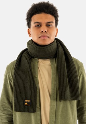 Scarf verde a coste realizzato in tessuto testurizzato, avvolto attorno al collo, con una piccola etichetta arancione con la scritta "Superdry Utility Wear."