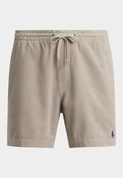 Short en velours côtelé beige avec taille élastique et cordon, avec un petit logo brodé bleu marine sur la partie inférieure de la jambe droite.