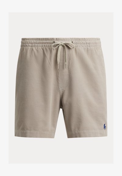 Short en velours côtelé beige avec taille élastique et cordon, avec un petit logo brodé bleu marine sur la partie inférieure de la jambe droite.